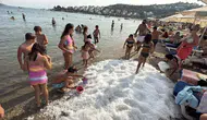 Bodrum’da sıcaktan bunalanlar sahile dökülen 2 ton buzla serinlediler
