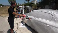Bursa'da mobil oto yıkamacı sokaktaki kirli araçları habersizce yıkıyor