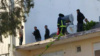 Antalya'da çatıya çıkan şahıs, gazeteciyle konuştuğu sırada polis tarafından aşağıya indirildi