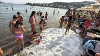 Bodrum’da sıcaktan bunalanlar sahile dökülen 2 ton buzla serinlediler