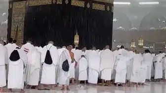 Mekke'de sağanak yağmur altında Kabe'de akşam namazı