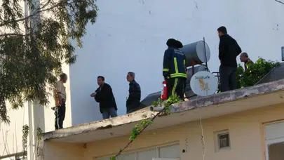 Antalya'da çatıya çıkan şahıs, gazeteciyle konuştuğu sırada polis tarafından aşağıya indirildi