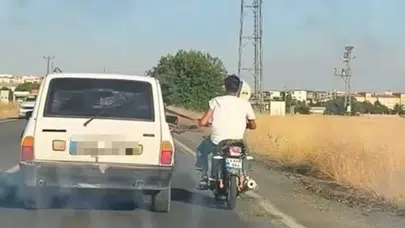 Şanlıurfa'da otoyolda tehlikeli anlar : Otomobilin emniyet kemerine tutunan motosikletli kamerada