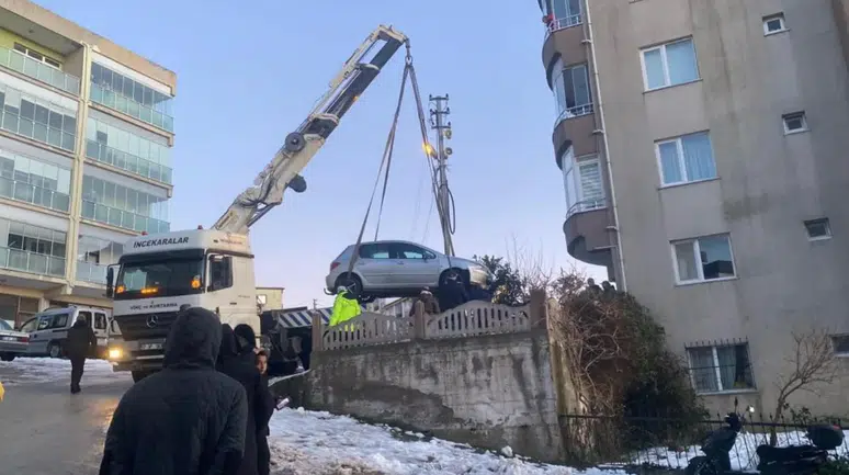 Sinop'ta buzdan dolayı kayan otomobil, apartman bahçesine düştü